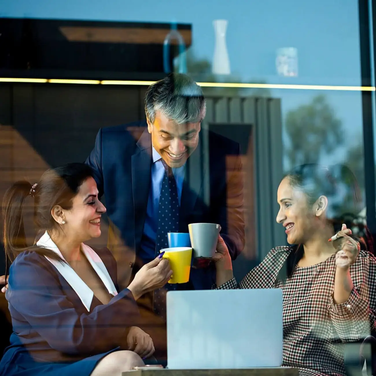 Coworkers drinking out of mugs in casual setting